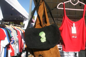 black handbag with embroidered sonny angel and red cropped tank top with cherry mitskis